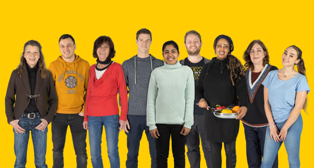 Das Team der Kita Kids Bockenheim mit gelben Hintergrund